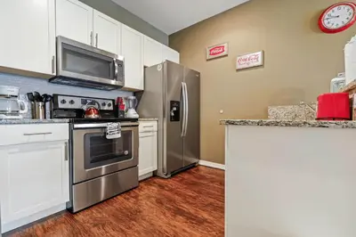a kitchen with stainless steel appliances and white cabinets at Family Spacious 3BR Townhouse with BBQ n' Pool Access in Kissimmee