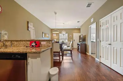 a kitchen and living room with a counter and a dining room at Family Spacious 3BR Townhouse with BBQ n' Pool Access in Kissimmee