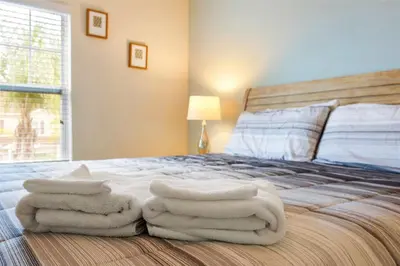 a bedroom with white towels on a bed at Family Spacious 3BR Townhouse with BBQ n' Pool Access in Kissimmee