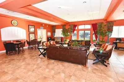 a living room with orange walls and a couch at Oakwater Retreat condo in Orlando