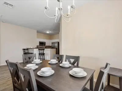a dining room with a table and chairs and a kitchen at Oakwater Retreat condo in Orlando