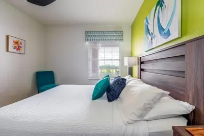 a bedroom with a large bed with a wooden headboard at Your Vista Cay Lakeview Allure condo in Orlando