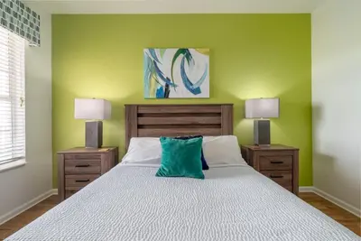a bedroom with a bed with a green wall at Your Vista Cay Lakeview Allure condo in Orlando