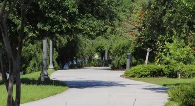 a walkway through a park with trees and grass at Your Vista Cay Lakeview Allure condo in Orlando