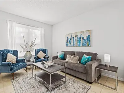 a living room with a couch and two chairs at Treasure Hunt Retreat home in Kissimmee