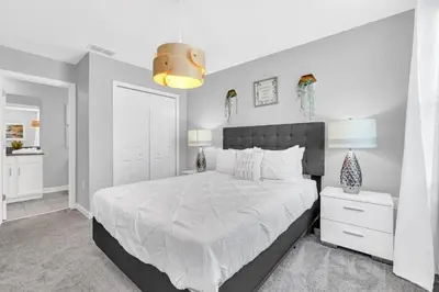 a bedroom with a large white bed and a lamp at Storey Lake 6 bed Home- King Master on 1st Floor villa in Kissimmee