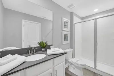 a white bathroom with a sink and a toilet at Storey Lake 6 bed Home- King Master on 1st Floor villa in Kissimmee