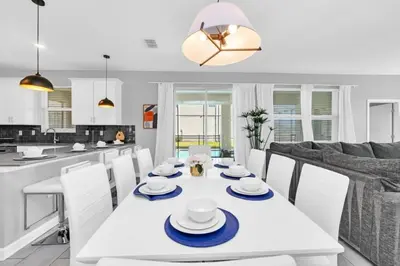 a dining room and kitchen with a white table and chairs at Storey Lake 6 bed Home- King Master on 1st Floor villa in Kissimmee