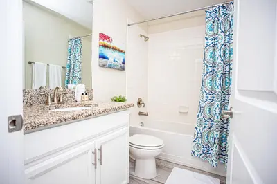 a bathroom with a sink and a toilet and a tub at Storey Lake Pool Home with Resort Amenities near DISNEY in Kissimmee