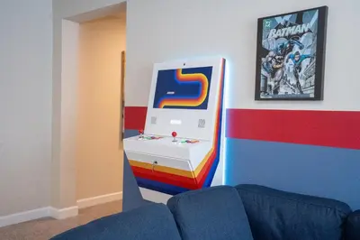 a room with a gaming machine on a wall at Storey Lake Pool Home with Resort Amenities near DISNEY in Kissimmee