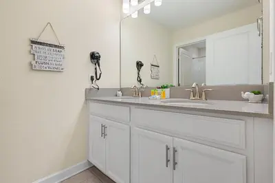 a bathroom with a sink and a mirror at 4978 Luxurious 4BR Sunshine Getaway at Storey Lake in Kissimmee