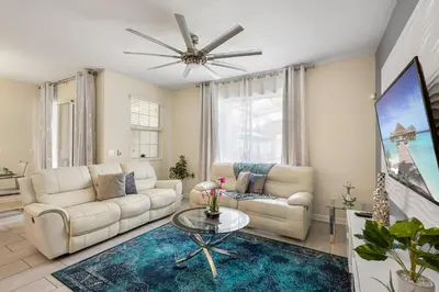 a living room with white furniture and a ceiling fan at 4978 Luxurious 4BR Sunshine Getaway at Storey Lake in Kissimmee