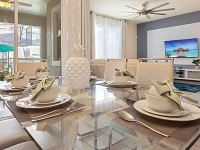a dining room with a glass table and chairs at 4978 Luxurious 4BR Sunshine Getaway at Storey Lake in Kissimmee