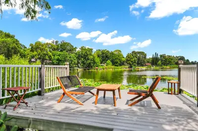 a wooden deck with two chairs and a table and chairs at Spring-Fed Lake King Suite Pet Friendly in Orlando