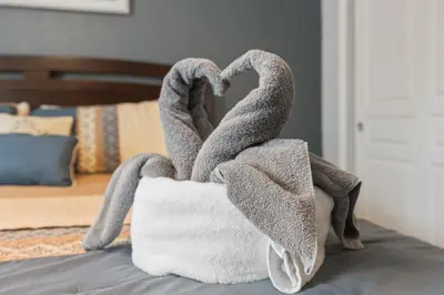 a towel sculpture of swans sitting on a bed at Modern Luxury 6 Bed Pool Home Close To Disney in Orlando