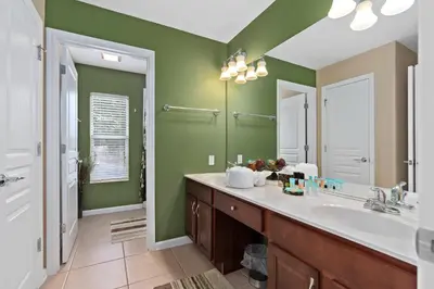 a bathroom with a sink and a mirror at Modern Luxury 6 Bed Pool Home Close To Disney in Orlando