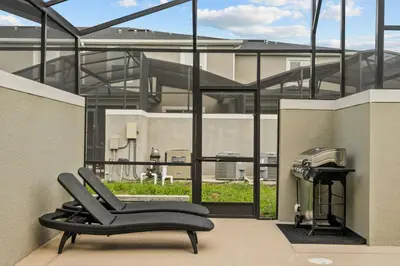 a black chair sitting on a balcony in front of a building at Modern design near Disney Top resort in Kissimmee
