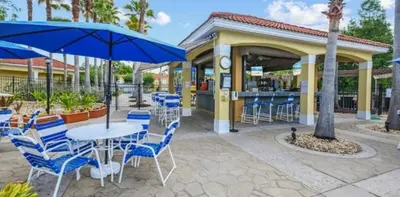 a patio with blue chairs and a table and umbrella at 201 HB - Hideaway at TerraVerde in Kissimmee