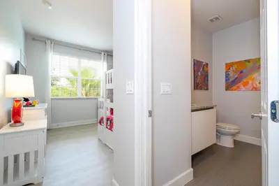 a white bathroom with a toilet and a window at Charming 3Bd w Pool Close to Disney at Serenity 1639 in Orlando