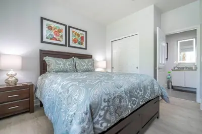 a bedroom with a bed with a blue comforter at Charming 3Bd w Pool Close to Disney at Serenity 1639 in Orlando