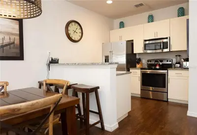 a kitchen with a table and a clock on the wall at 3 Bedroom 2 Bathroom Lucaya Village 15-103 in Kissimmee