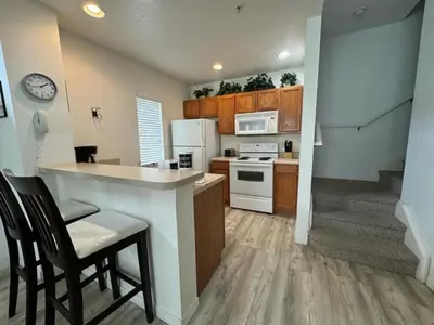 a kitchen with a counter and some chairs in a room at 4 Bedroom 3 Bathroom Villas At Seven Dwarfs 8-107 in Kissimmee