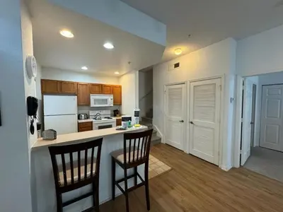 a kitchen with two chairs and a counter with a counter top at 4 Bedroom 3 Bathroom Villas At Seven Dwarfs 10-102 in Kissimmee