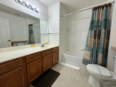 a bathroom with a sink and a toilet and a tub at 4 Bedroom 3 Bathroom Villas At Seven Dwarfs 10-102 in Kissimmee