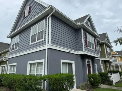 a gray house with red shutters on it at 4 Bedroom 3 Bathroom Villas At Seven Dwarfs 1-101 in Kissimmee