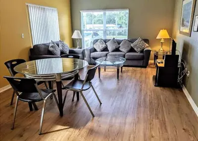a living room with a table and a couch at 4 Bedroom 3 Bathroom Villas At Seven Dwarfs 1-101 in Kissimmee