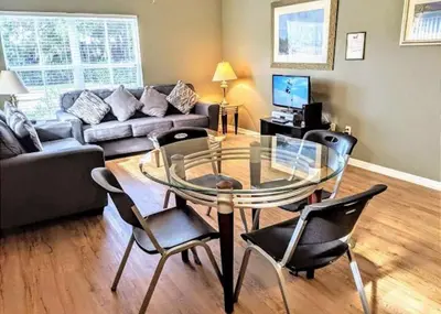 a living room with a glass table and chairs at 4 Bedroom 3 Bathroom Villas At Seven Dwarfs 1-101 in Kissimmee