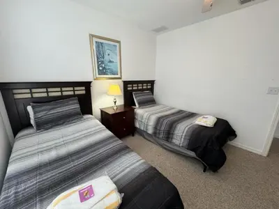 a bedroom with two beds and a lamp in it at 4 Bedroom 3 Bathroom Villas At Seven Dwarfs 1-101 in Kissimmee