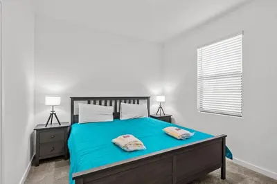 a bedroom with a blue bed with two pillows on it at 3 Bedroom 3 Bathroom The Hub At Westside Reserve 3300 TT in Kissimmee