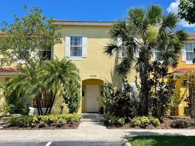 a yellow house with palm trees in front of it at 3 Bedroom 3 Bathroom Terra Verde 4766 in Kissimmee