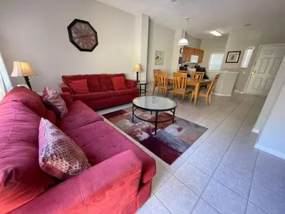 a living room with a red couch and a table at 3 Bedroom 3 Bathroom Terra Verde 4766 in Kissimmee