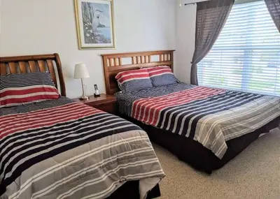 two beds sitting next to each other in a bedroom at 4 Bedroom 3 Bathroom Villas At Seven Dwarfs 8-108 in Kissimmee
