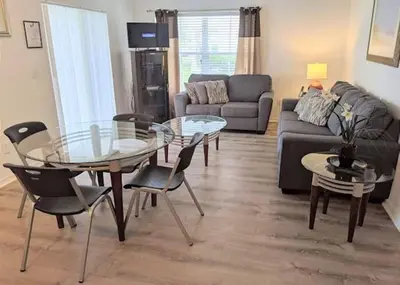 a living room with a glass table and chairs at 4 Bedroom 3 Bathroom Villas At Seven Dwarfs 8-108 in Kissimmee