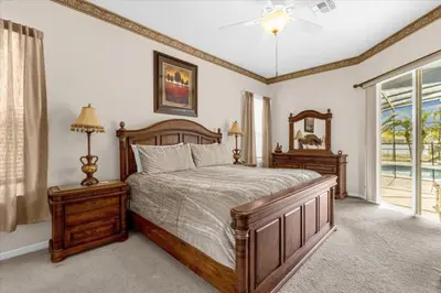 a bedroom with a wooden bed and a window at 4 Bedroom Value Plus Home with Private PooI in Orlando