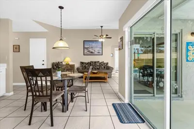 a dining room and living room with a table and chairs at 4 Bedroom Value Plus Home with Private PooI in Orlando
