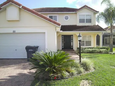 a house with a garage and a street light at 4 Bedroom Value Plus Home with Private PooI in Orlando