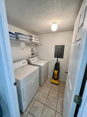 a small laundry room with a washer and dryer at Grand Emerald 3BR Condo Resort near Disney Parks in Kissimmee
