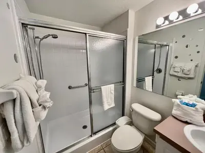 a bathroom with a shower and a toilet and a sink at Grand Emerald 3BR Condo Resort near Disney Parks in Kissimmee