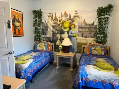 a bedroom with two beds and a disney mural at Shrek's Hideout! - 5 min from Disney! in Kissimmee