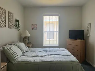 a bedroom with a bed and a television on a dresser at Shrek's Hideout! - 5 min from Disney! in Kissimmee