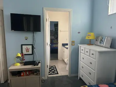a bedroom with blue walls and a tv on the wall at Shrek's Hideout! - 5 min from Disney! in Kissimmee