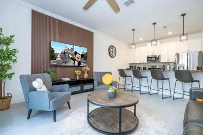 a living room with chairs and a tv on a wall at Condominium villas near Disney Orlando Florida in Kissimmee