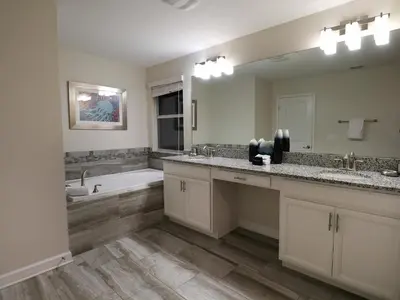 a bathroom with two sinks and a bath tub and a mirror at Themed 5BD Home Movie and Game Room 4726 in Kissimmee