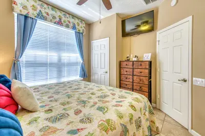 a bedroom with a bed and a window at Magical Getaway Close to Disney! Pool, Gym, & WiFi in Kissimmee
