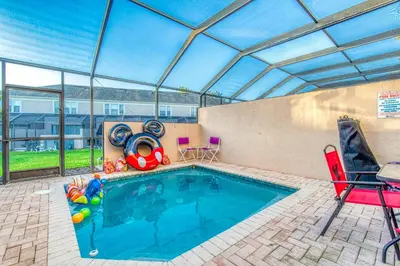 a swimming pool in a house with a glass ceiling at Magical Getaway Close to Disney! Pool, Gym, & WiFi in Kissimmee