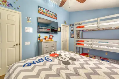 a childs bedroom with a bed and bunk beds at Magical Getaway Close to Disney! Pool, Gym, & WiFi in Kissimmee